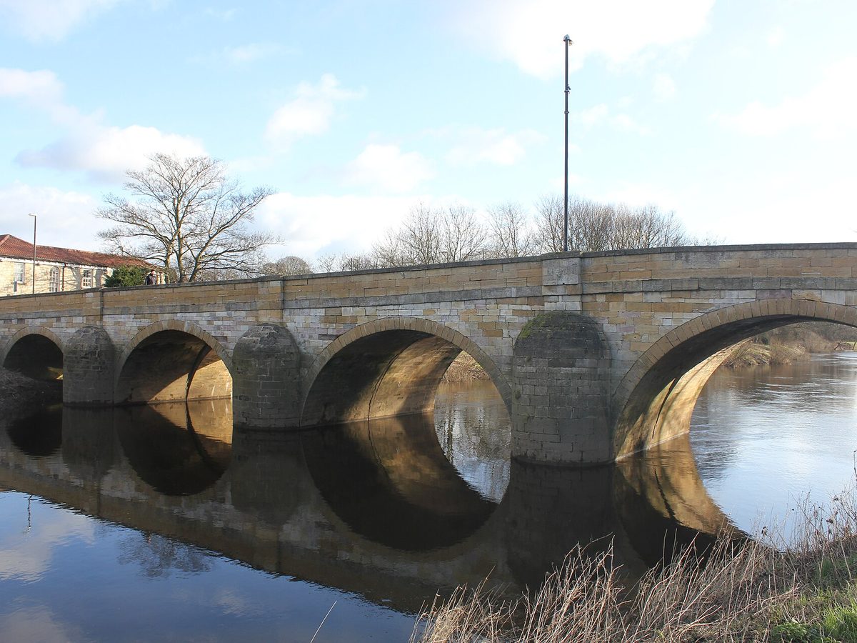 Tadcaster Bridge over the River Wharfe. Photo by Dr Ivan Hall, CC BY-SA 3.0, via Wikimedia Commons. Tadcaster Bridge over the River Wharfe